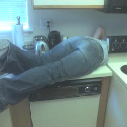 Jess crawling behind stove